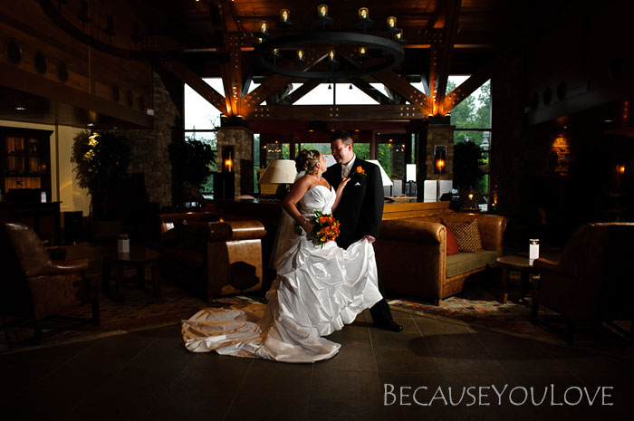 The bride and groom embrace in the lobby of a ski lodge.